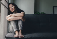 anxious and worried girl leaning against window with anxiety
